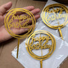 A set of ten gold acrylic birthday cake toppers with the words Happy Birthday on them, displayed in clear plastic packaging.