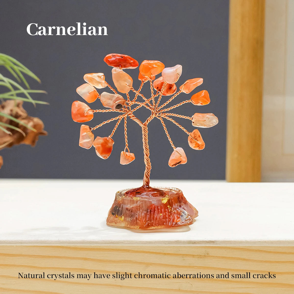 A Carnelian crystal tree featuring natural orange and amber stones mounted on a glass base.