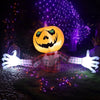An inflatable Halloween pumpkin decoration with glowing eyes and a plaid shirt, illuminated by purple string lights.