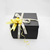 A black gift box tied with a yellow ribbon and a gold bow, labeled Just for you.
