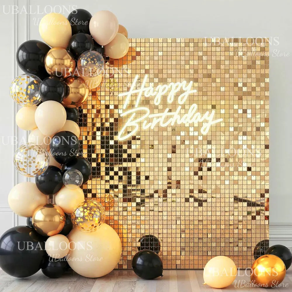 A gold and black sequin mosaic wall backdrop decorated with round balloons and the text Happy Birthday