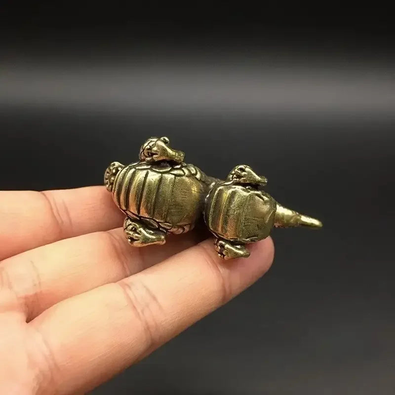 Handcrafted brass dragon statue resting on a person's palm.