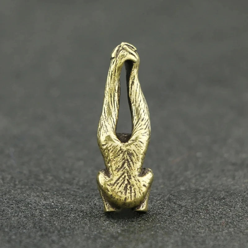 Vintage brass monkey key chain charm with an elongated, stylized monkey figure.