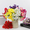 A bouquet of artificial pansy flowers in yellow, white, and pink clustered together.