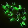 A set of twelve luminous green butterfly wall stickers displayed against a dark background.