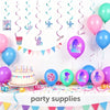 A collection of pink and purple K-Pop themed party supplies including balloons, streamers, and a cake on a white table.
