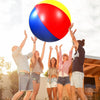 Five young adults are celebrating outdoors while holding a large inflatable pool party ball above their heads.