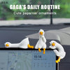 A white resin cartoon duck figurine is shown resting on a car dashboard next to a smartphone displaying a map.