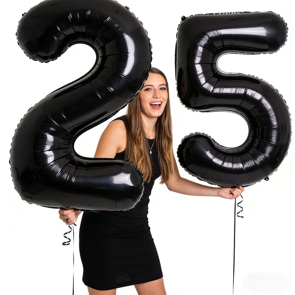 A young woman holds up giant black foil balloons shaped like the number 25.