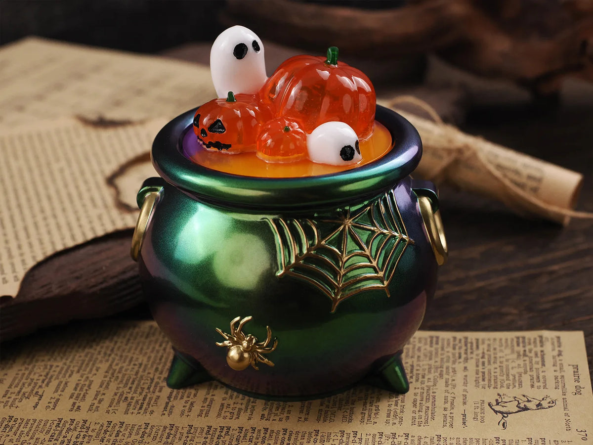 A green glass jar filled with orange liquid holds a Halloween silicone mold set featuring pumpkin and ghost shapes.