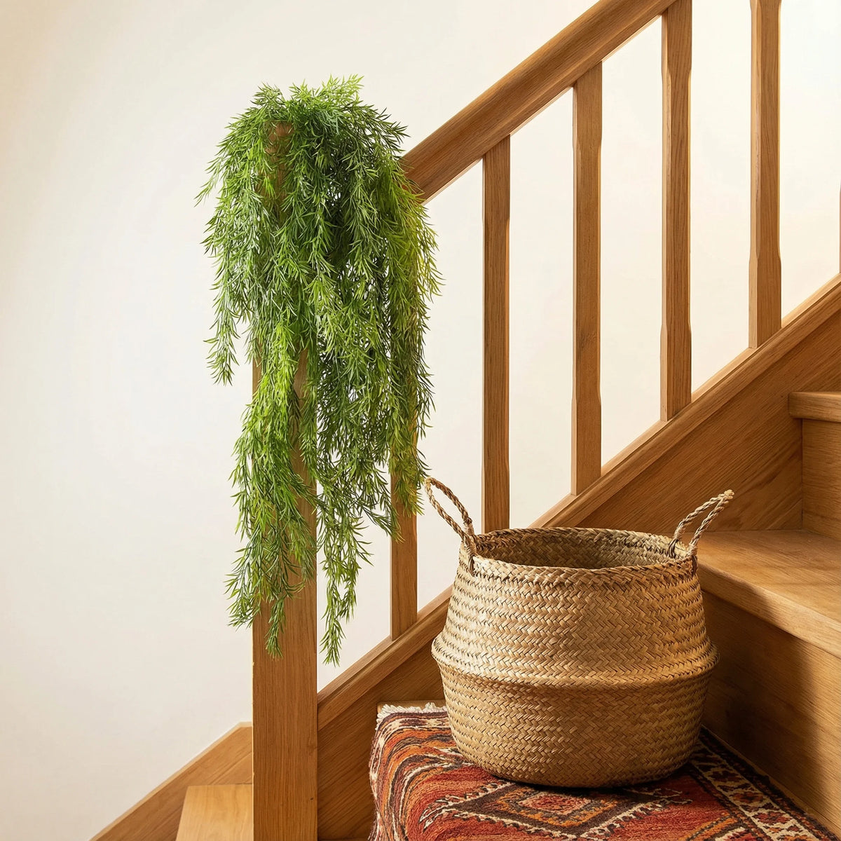 Künstliche Eukalyptus-Pinienranken Wanddekoration auf Holzgeländer und Treppe.