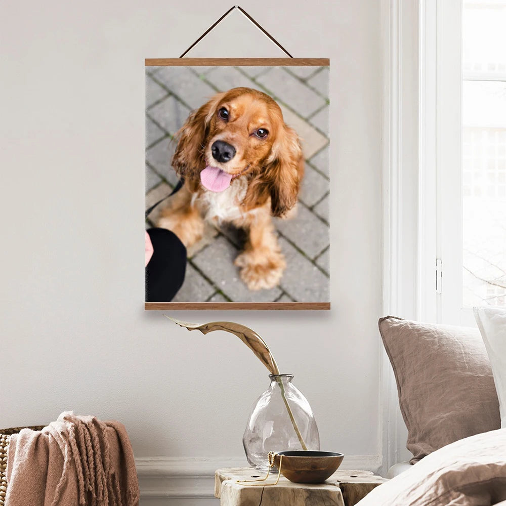 A framed photograph of a happy, light brown dog with floppy ears and a pink tongue, displayed on a white wall.