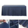 A dark blue stretch rectangle tablecloth draped over a table, showing the fabric texture and pleats.