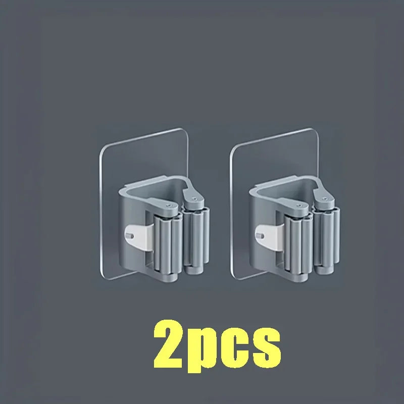 Two wall mounted holders for a mop and broom, shown in gray against a dark background.