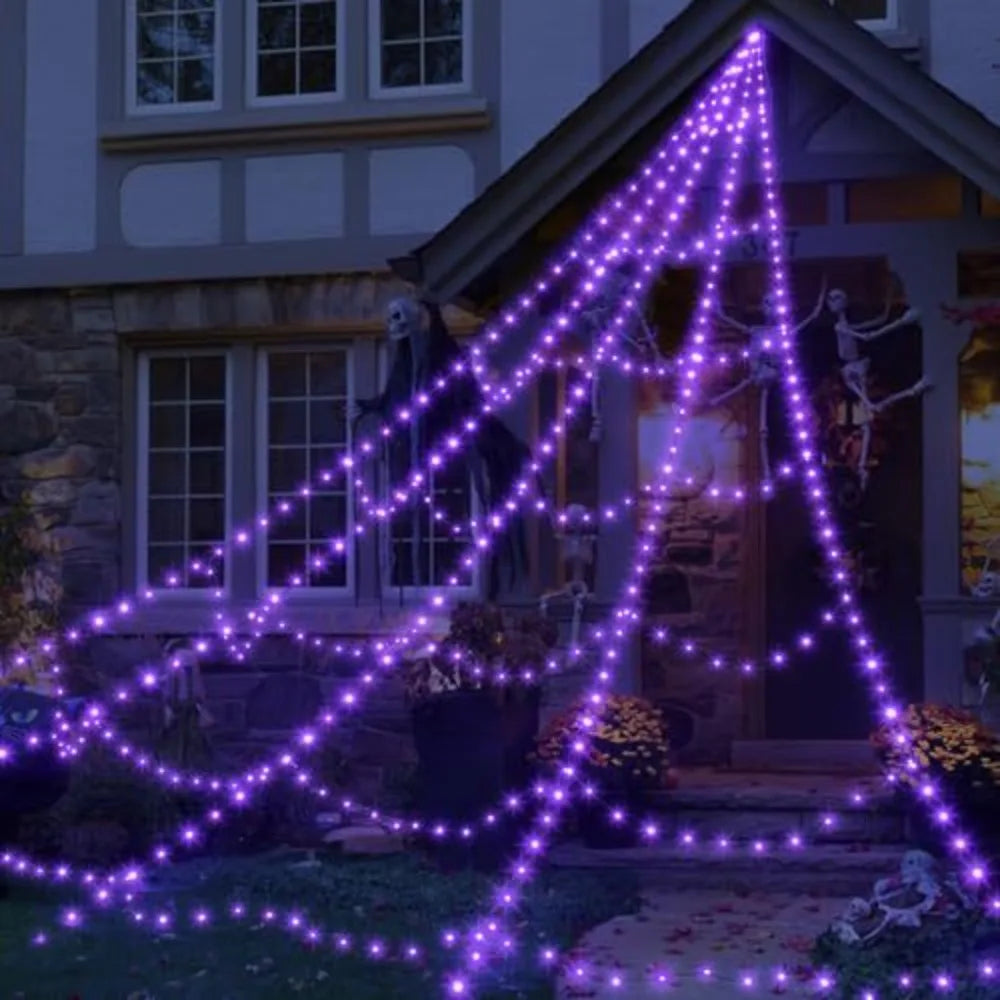 Purple Halloween spider web lights strung across a porch and garden area.