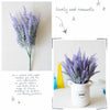A bouquet of purple lavender flowers in a white ceramic pot on a light surface.
