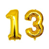 Two gold foil number balloons shaped like 1 and 3 for a birthday party
