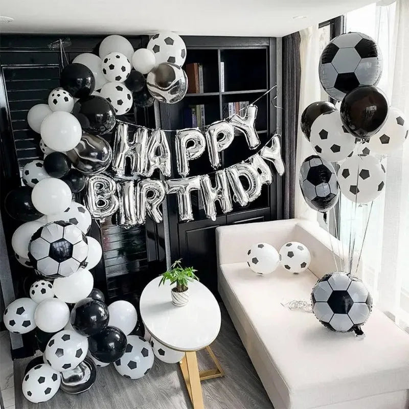 A display of silver and black latex football shaped balloons arranged in a festive party backdrop.