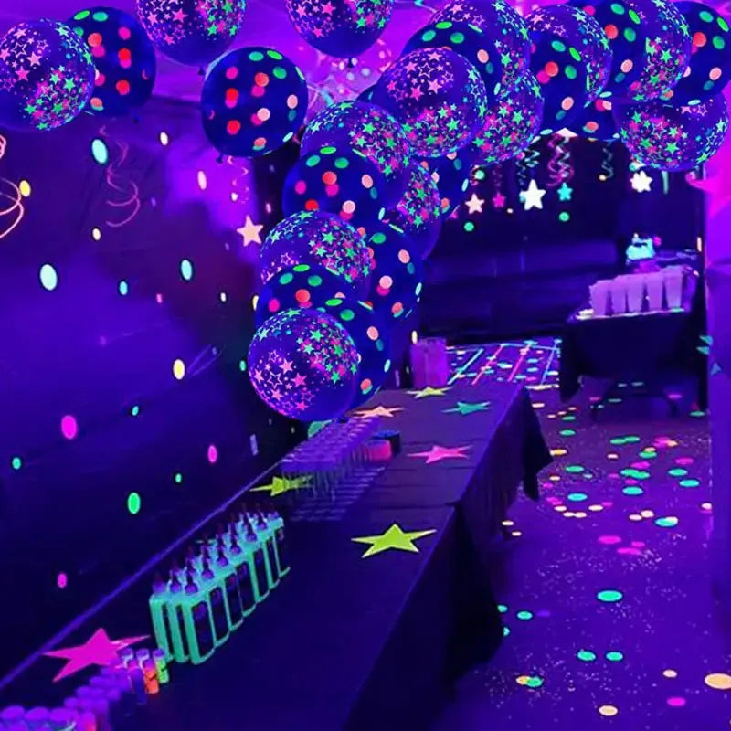 Nahaufnahme leuchtend lila und grün latexballons auf dunker Oberfläche mit funkelnden Lichtern