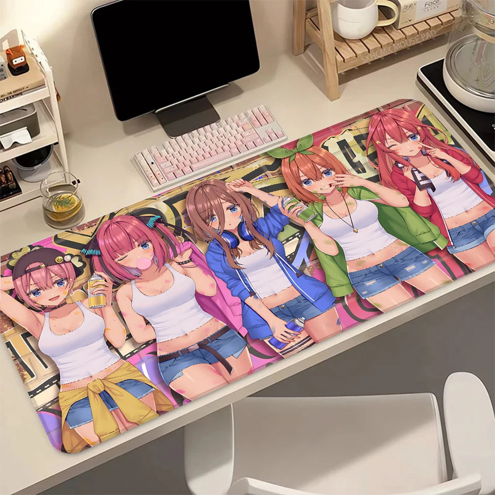 A desk mat featuring five female anime characters from The Quintessential Quintuplets series with a colorful background.