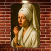 A painting of a woman wrapped in white cloth with red lipstick, displayed on a brick wall.