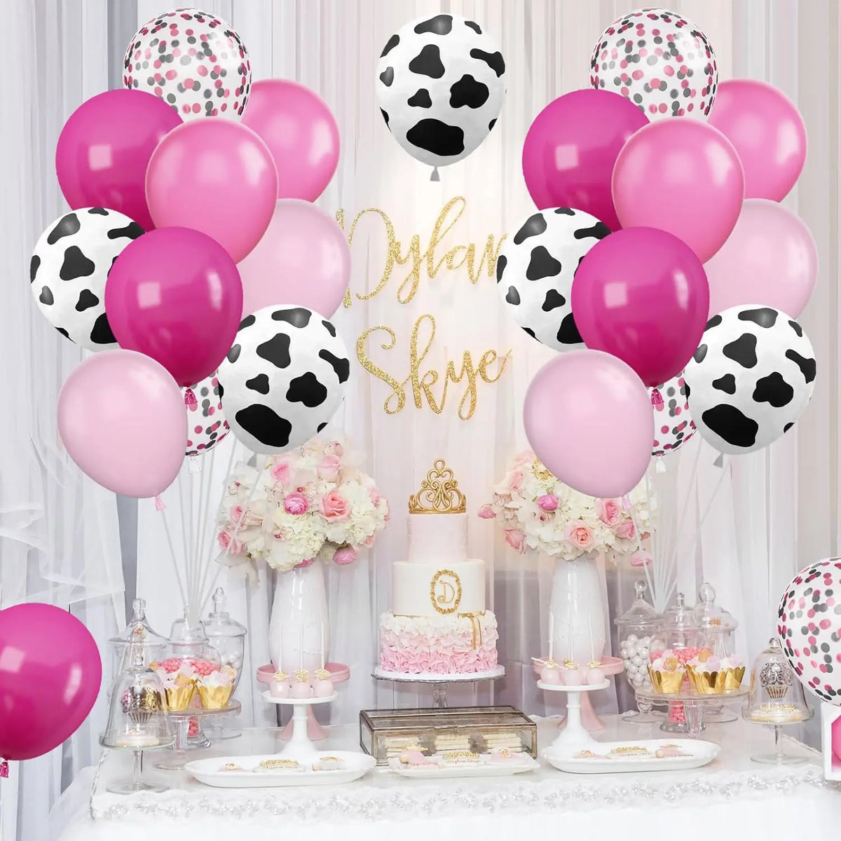 A display of pink and black cow print balloons for a farm-themed party decoration.