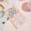 A set of gradient blue metallic birthday candles is displayed on a pink card against a light background.