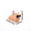 A small, orange cartoon animal figurine with a white snout and red tuft on top, shown next to a measurement scale.