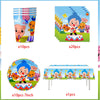 A set of circus theme birthday party decor including cups, cards, and a table runner with character figures.