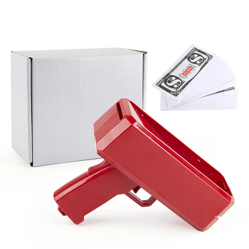 A red money shooter toy box and several stacks of fake money are shown on a white background.