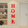 Red letter wall decals spelling out HOME on a beige wall next to a white door.
