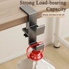 A close-up of a strong load-bearing desk hook with a red handle, mounted on a white surface.