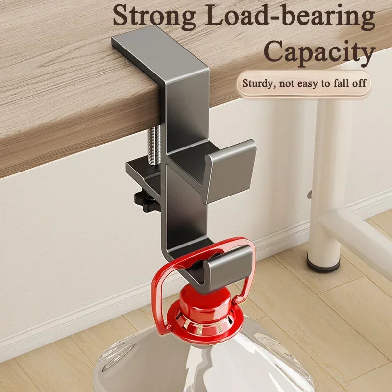 A close-up of a strong load-bearing desk hook with a red handle, mounted on a white surface.