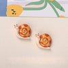 Two resin fridge magnets shaped like snails with orange spiral shells and small white heads.