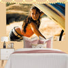 Megan Fox wall art tapestry featuring a woman in an orange top and black leather, displayed above a bed.