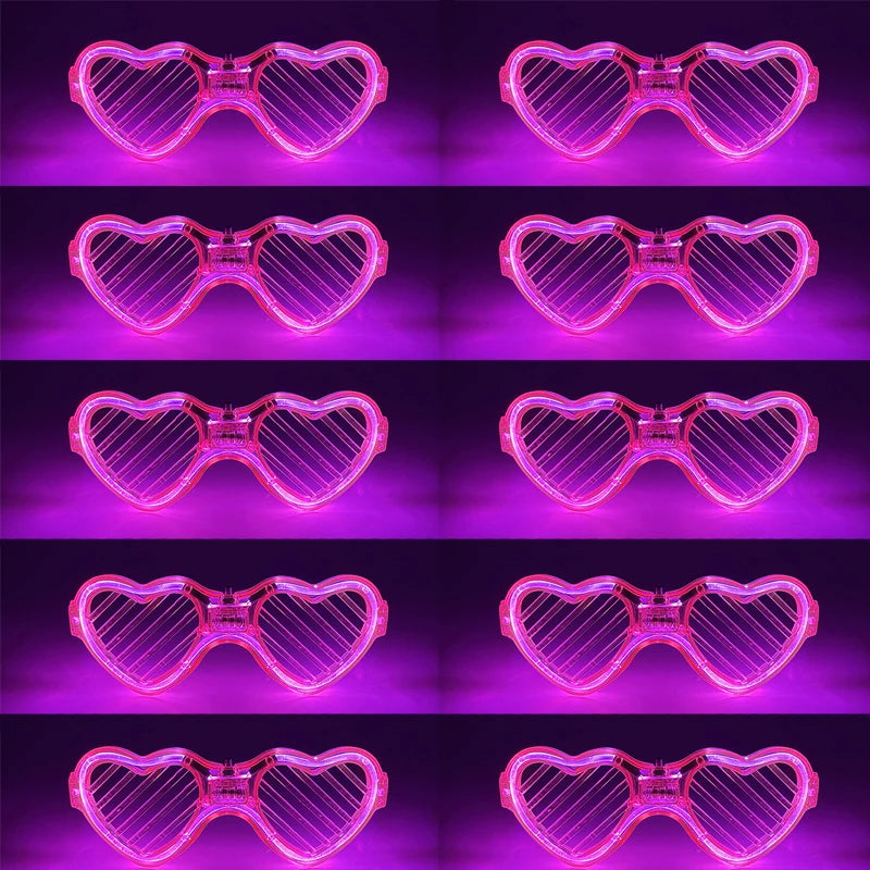 Ein Set fluoreszierender rosa Herz-Partybrillen in verschiedenen Winkeln und Beleuchtung.