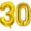 A large, shiny gold foil balloon shaped like the number 30.