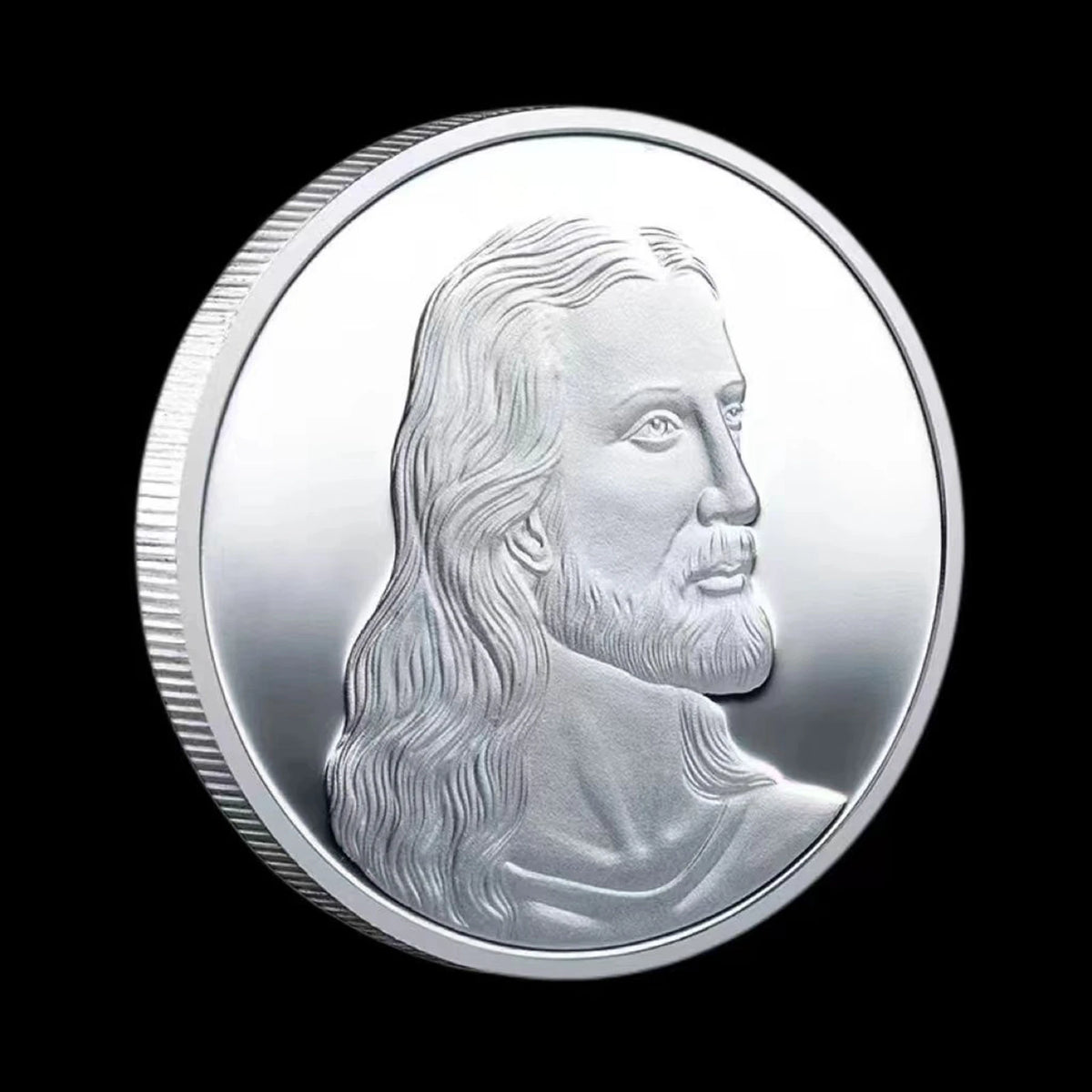 A silver commemorative metal coin featuring a profile portrait of Jesus Christ.
