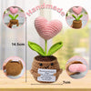Handmade crochet plant decoration featuring a pink heart flower and an inspirational card on a brown pot.