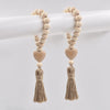 A pair of handmade wood and jute bead garlands hanging on a white rod.