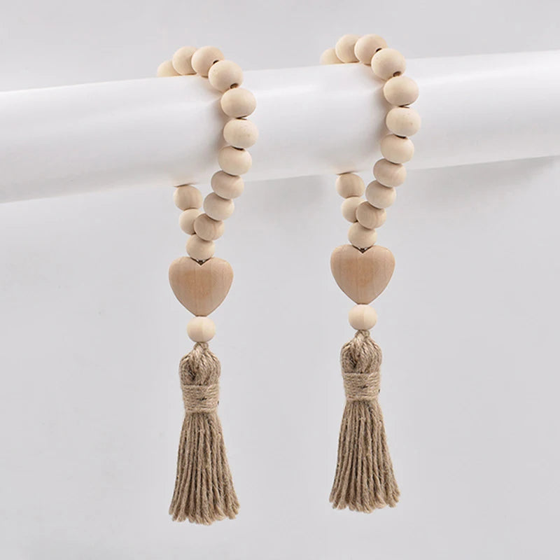 A pair of handmade wood and jute bead garlands hanging on a white rod.