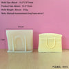 A rectangular silicone mold shaped like a handbag is shown against a pink wall.