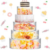 A tiered display of colorful floral and candy-themed cakes on clear acrylic stands.