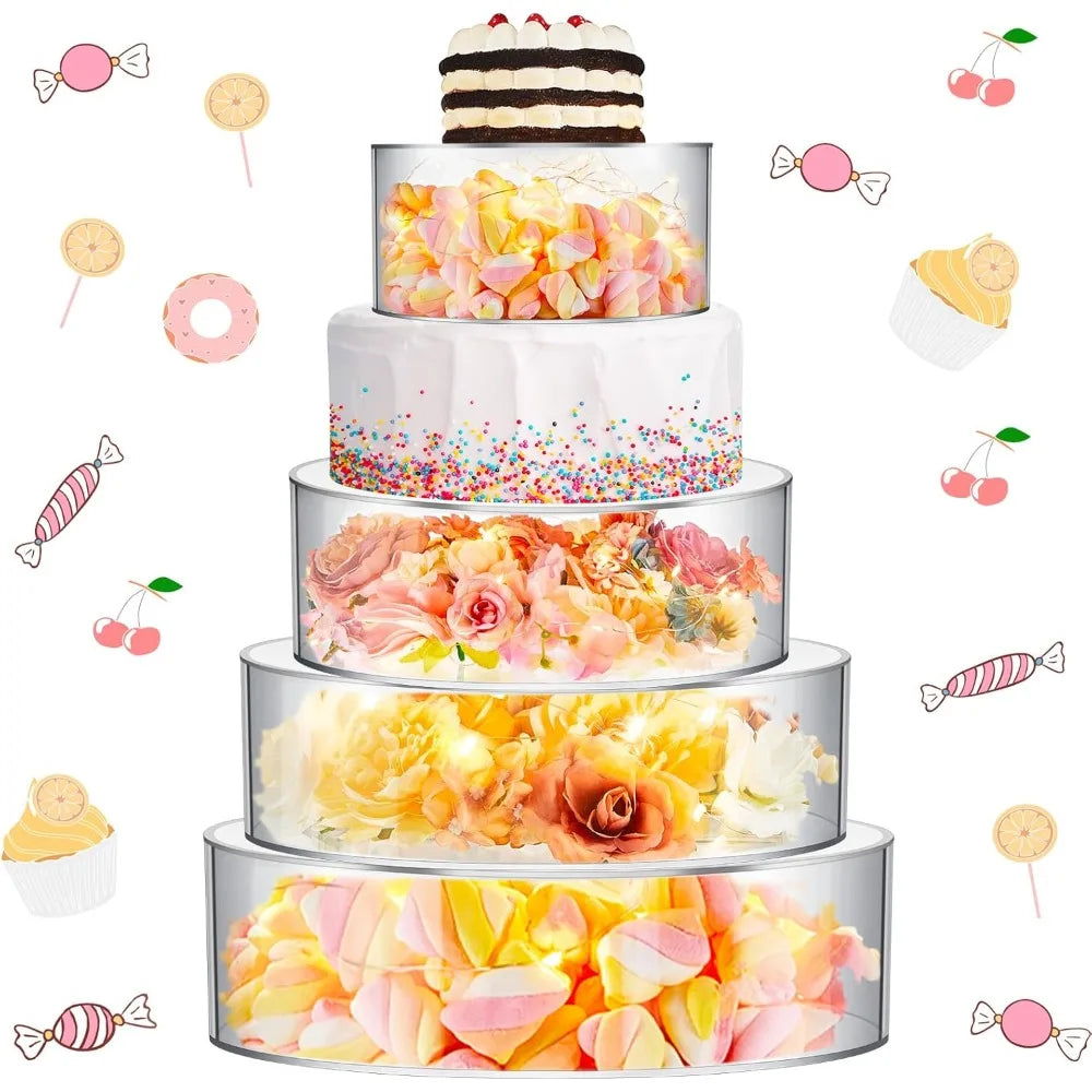 A tiered display of colorful floral and candy-themed cakes on clear acrylic stands.