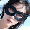 A close-up of a woman wearing a black PU leather cat eye masquerade mask.