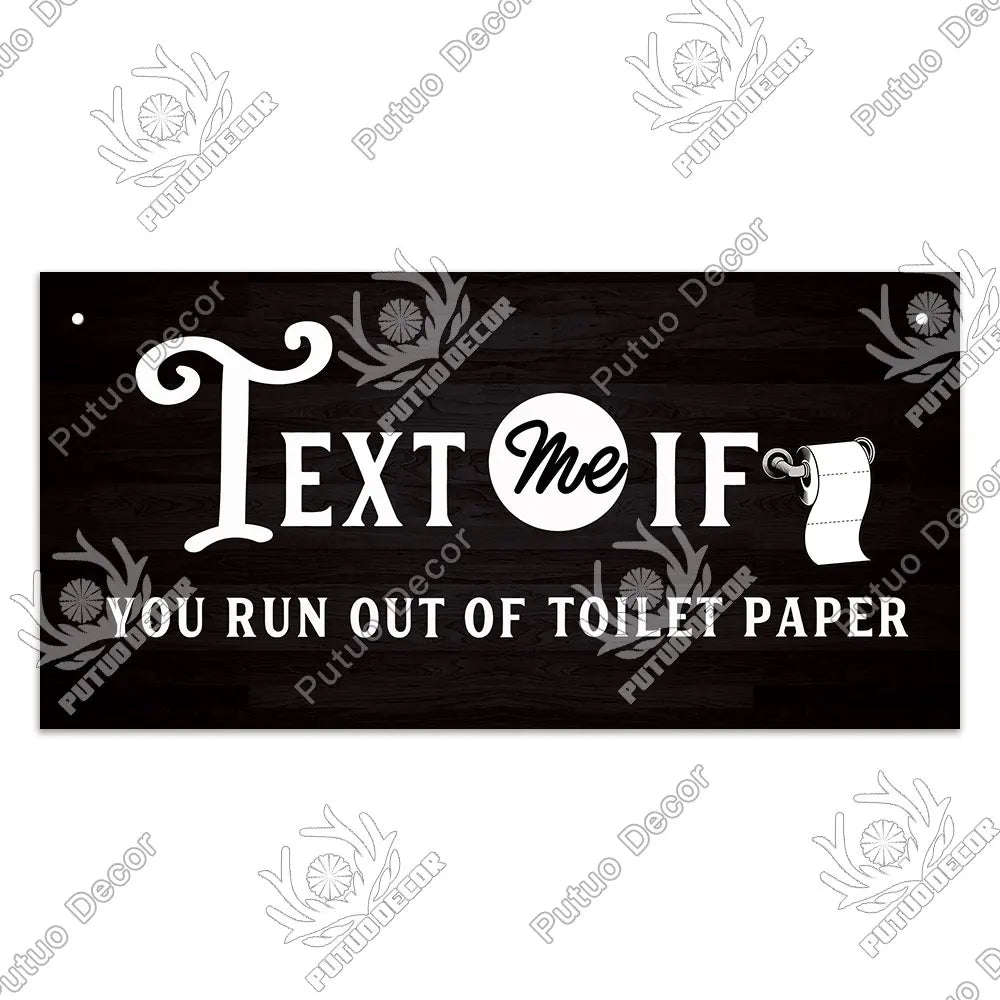 A rustic wooden sign with white text that reads Text me if you run out of toilet paper.