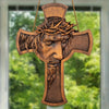A wooden cross wall decor featuring a carved depiction of Jesus with a crown of thorns.