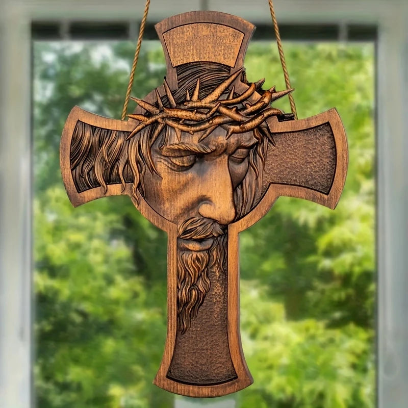 A wooden cross wall decor featuring a carved depiction of Jesus with a crown of thorns.