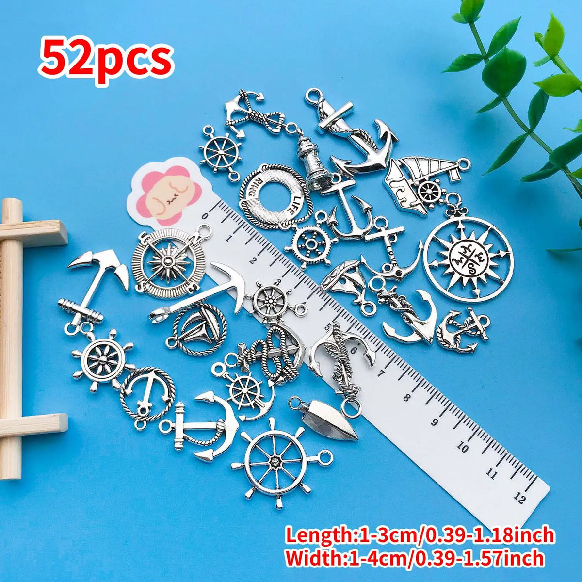 52 pieces of vintage ship anchor charms and nautical jewelry components laid out on a blue background