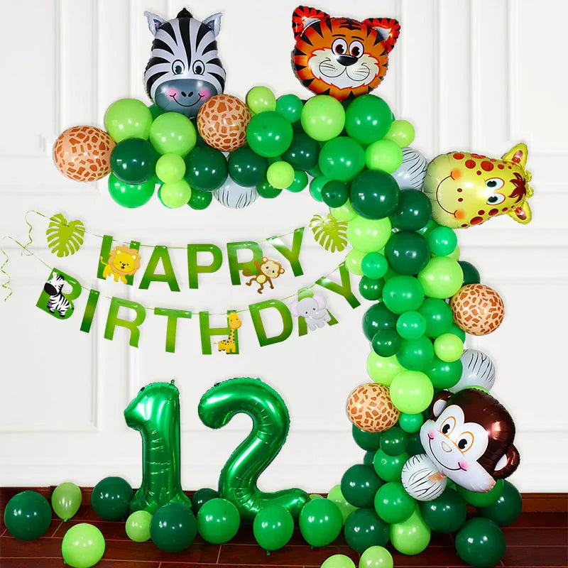 A green balloon garland arch decorated with safari animals like a tiger and zebra for a birthday celebration.